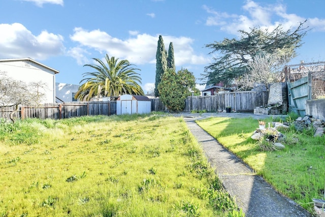 view of yard with an outbuilding, a shed, and a fenced backyard