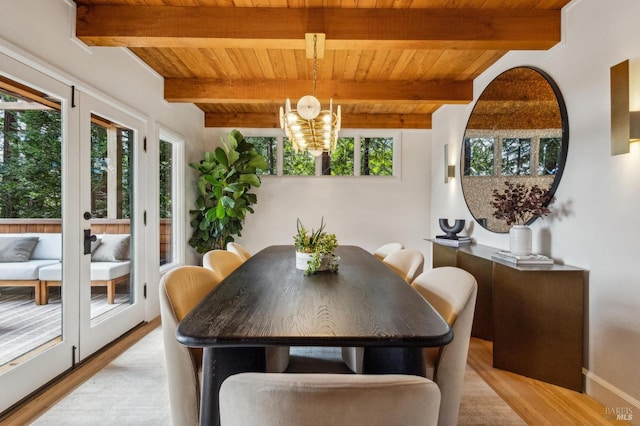 dining space featuring beam ceiling, wood ceiling, light wood-style floors, and an inviting chandelier