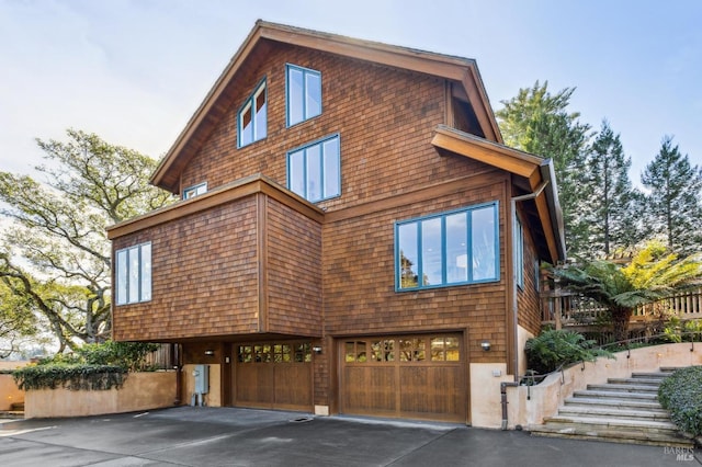 view of front facade featuring driveway, stairs, and a garage