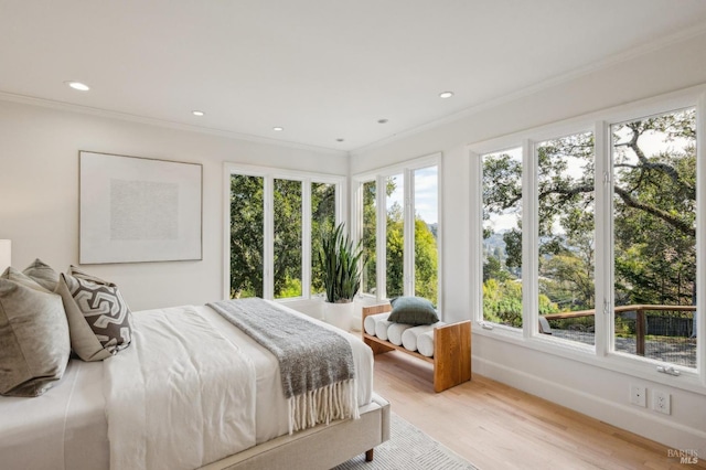 bedroom with recessed lighting, crown molding, baseboards, and wood finished floors