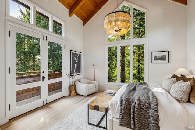 bedroom with wood ceiling, beam ceiling, an inviting chandelier, wood finished floors, and access to outside