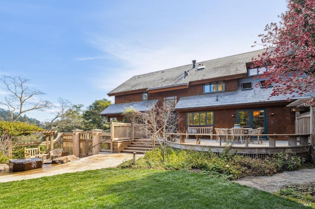 back of house featuring fence, an outdoor fire pit, a deck, a yard, and a patio area