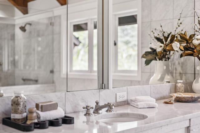 full bathroom with vanity, a shower stall, and tasteful backsplash