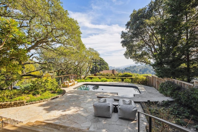 view of swimming pool featuring a patio and fence