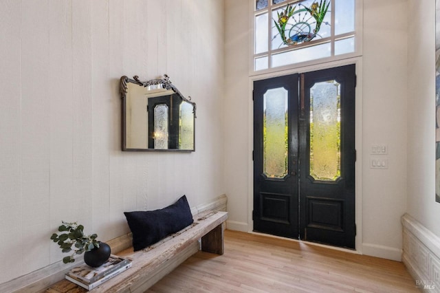 entrance foyer with french doors, light wood-type flooring, and baseboards