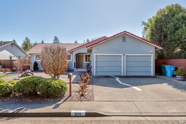 ranch-style house with stucco siding, a garage, concrete driveway, and fence