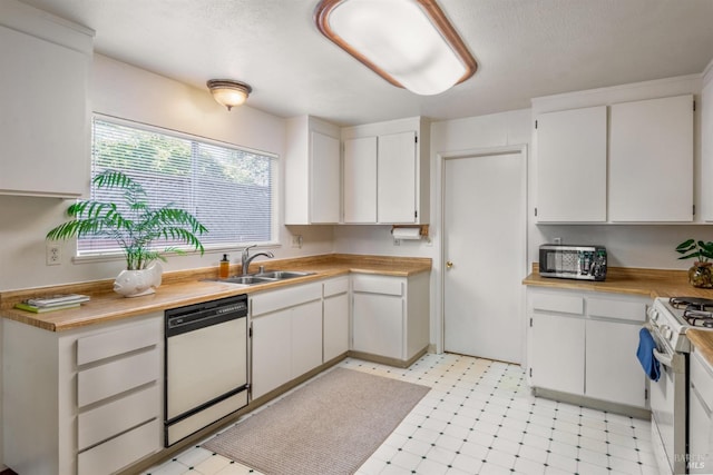 kitchen featuring a sink, white appliances, light floors, and white cabinetry