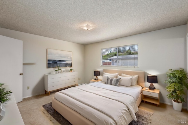 bedroom featuring light colored carpet, a textured ceiling, and baseboards