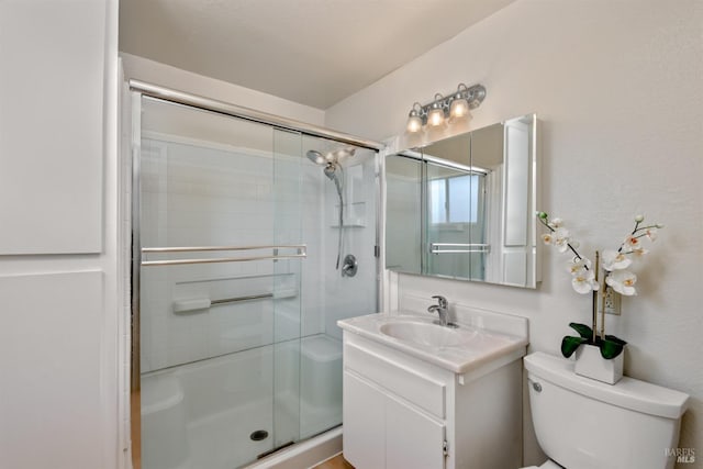 full bath with toilet, vanity, and a shower with shower door