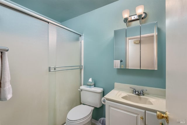 bathroom featuring vanity, toilet, and a shower with door