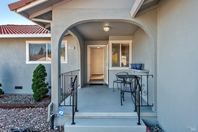 entrance to property featuring crawl space and stucco siding