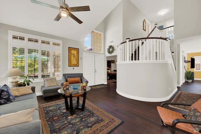 living room featuring stairway, wood finished floors, baseboards, and high vaulted ceiling