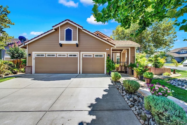 view of front of property with brick siding, fence, a tile roof, a garage, and driveway