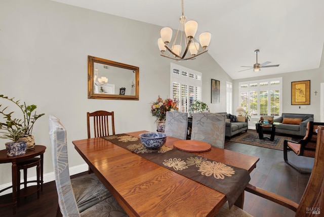 dining space featuring vaulted ceiling, ceiling fan with notable chandelier, baseboards, and wood-type flooring