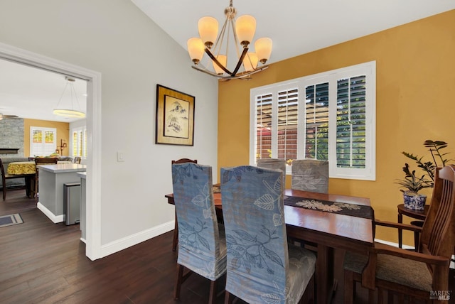 dining area featuring an inviting chandelier, baseboards, and dark wood-style flooring