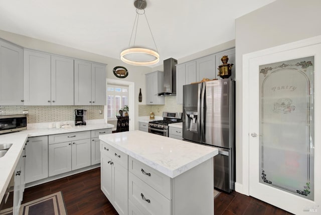 kitchen featuring decorative backsplash, dark wood-type flooring, wall chimney range hood, and stainless steel appliances