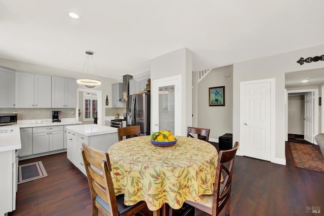 dining room with recessed lighting, baseboards, and dark wood finished floors