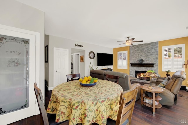 dining space featuring a fireplace, wood finished floors, and a ceiling fan