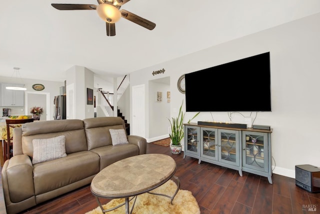 living room with stairway, wood finished floors, baseboards, and ceiling fan