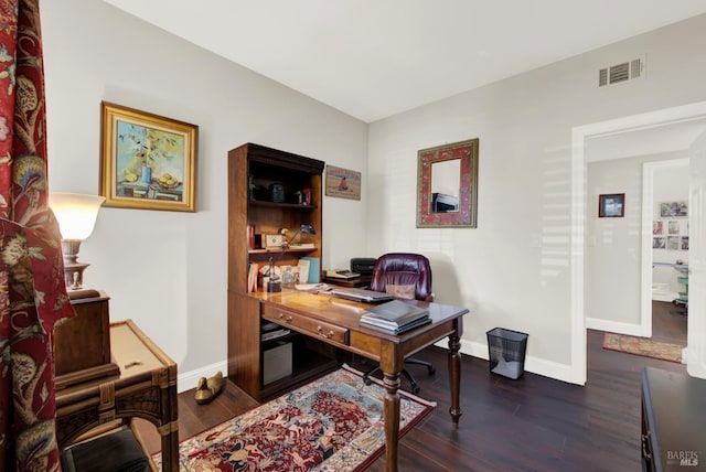 office space featuring dark wood finished floors, visible vents, and baseboards