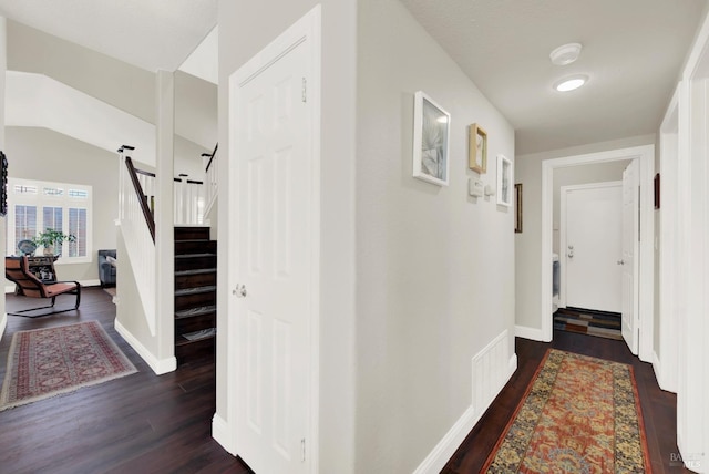 corridor featuring stairway, dark wood-style floors, and baseboards