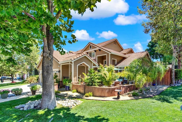 mediterranean / spanish-style home with a tile roof, a front lawn, and driveway