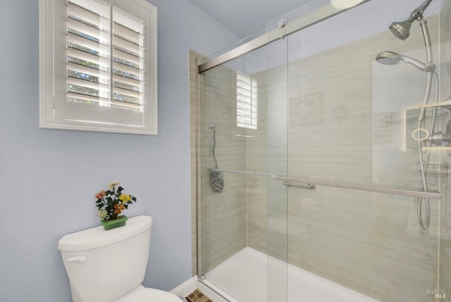 full bathroom with a shower stall and toilet