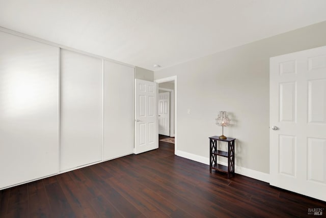 unfurnished room featuring baseboards and wood finished floors