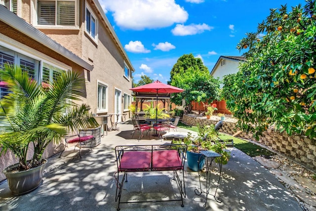 view of patio featuring outdoor dining area and fence