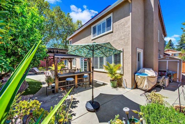 view of patio with a gazebo, an outdoor structure, a storage unit, and outdoor dining area