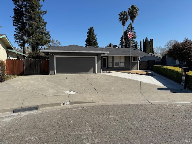 single story home with concrete driveway, a garage, and fence