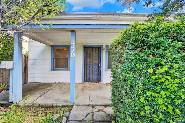 view of exterior entry with covered porch