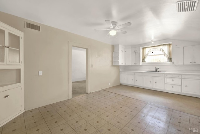 kitchen with a sink, visible vents, light floors, and a ceiling fan