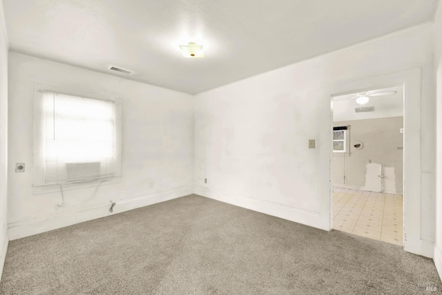 spare room featuring a ceiling fan, visible vents, and carpet floors