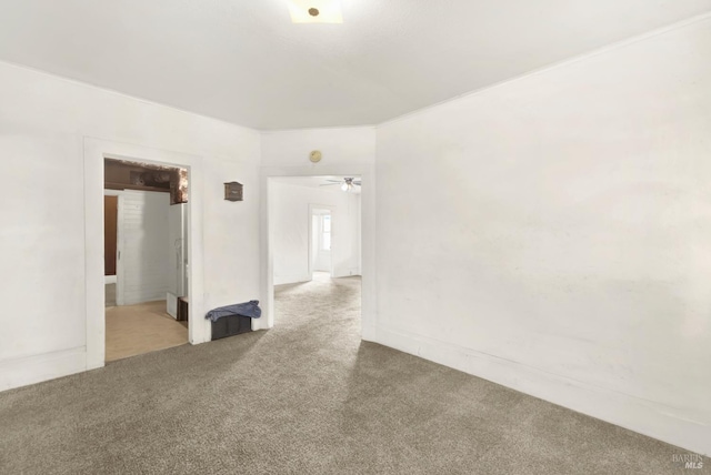 carpeted spare room featuring a ceiling fan