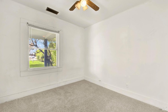 empty room with visible vents, light colored carpet, and ceiling fan