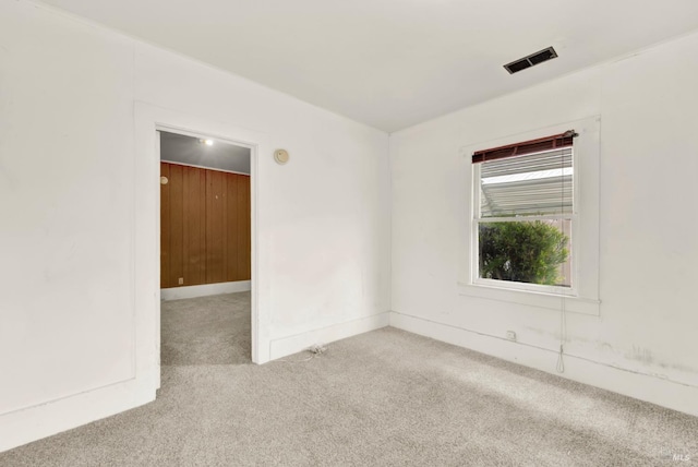 carpeted empty room featuring visible vents