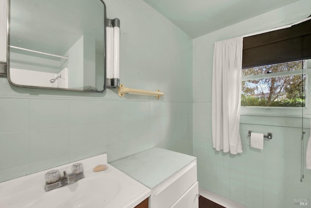 bathroom with vanity and tile walls