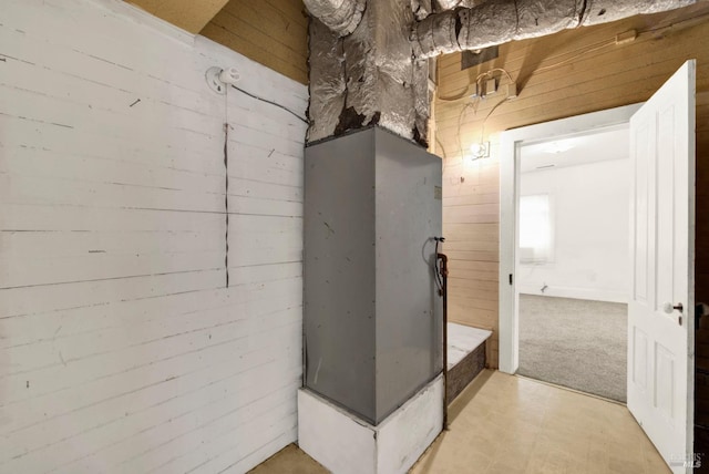 bathroom with tile patterned floors and wood walls