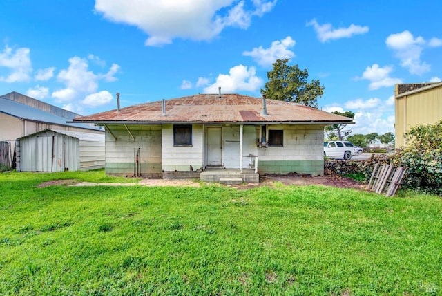 rear view of property with an outdoor structure, a yard, and a shed