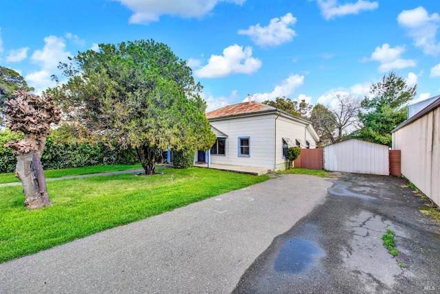 exterior space featuring aphalt driveway and a lawn