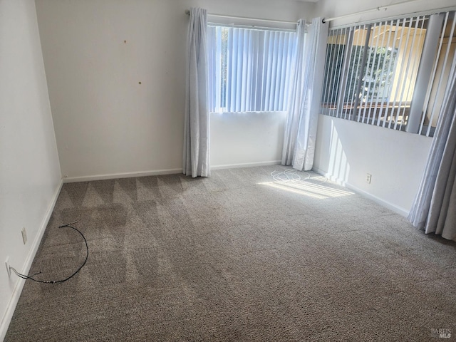 empty room featuring baseboards and carpet floors