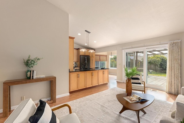 living area featuring recessed lighting, visible vents, light wood finished floors, and baseboards