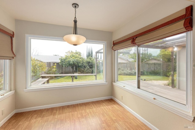 unfurnished dining area featuring light wood finished floors and baseboards