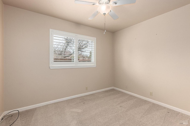 spare room featuring baseboards, a ceiling fan, and carpet