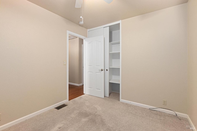 unfurnished bedroom with a ceiling fan, a closet, baseboards, carpet flooring, and visible vents