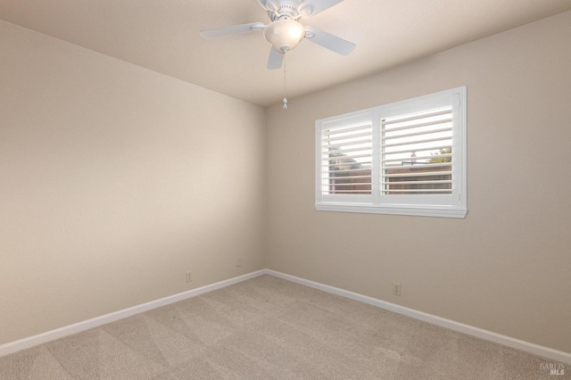 empty room featuring light carpet, a ceiling fan, and baseboards