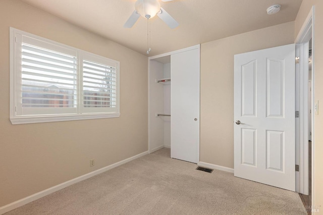 unfurnished bedroom featuring visible vents, baseboards, carpet, a ceiling fan, and a closet