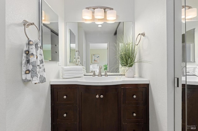 bathroom featuring a textured wall and vanity