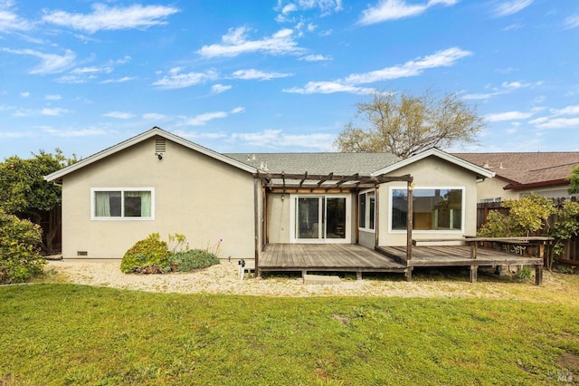 rear view of property with a pergola, fence, a lawn, a deck, and stucco siding
